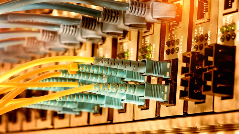 Bank of fiber optic cables plugged in to receptacles.